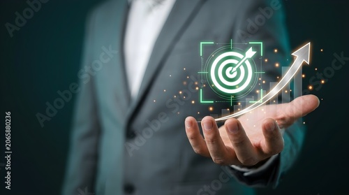 Businessman holding a digital target icon with growth graph for business strategy