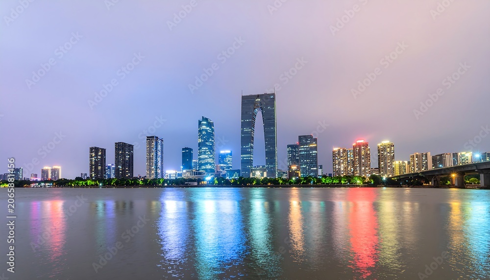 Fototapeta premium City skyline reflection on calm water at dusk.