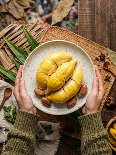 Hands Presenting Golden Durian Fruit
