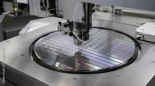 close up of semiconductor wafer with circuit pattern under processing equipment
