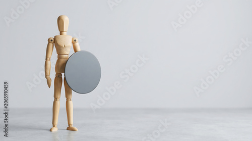 Employee performance protection concept with wooden mannequin holding circular shield for HR evaluation and business risk analysis presentation
