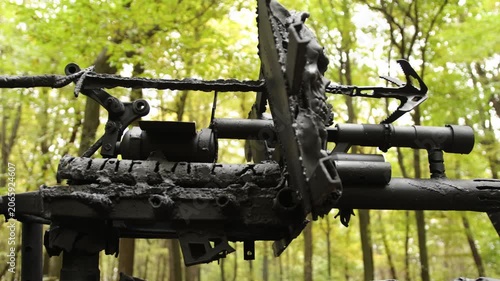 Forest setting, heavy armor, aggressive design. Detailed shot showing metallic, armored structure with aggressive, sharp attachments in wooded, post-apocalyptic setting.