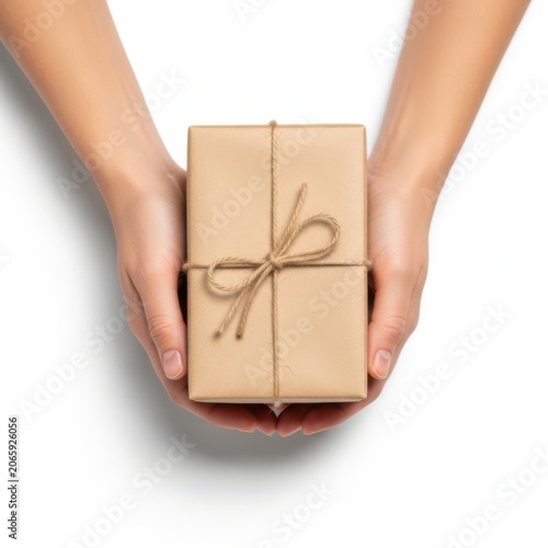 Two human hands holding a small cardboard gift box wrapped with brown string isolated on white background