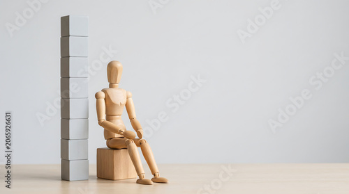 Performance review and KPI tracking business concept with wooden figure next to block tower with copy space for HR evaluation presentation banner