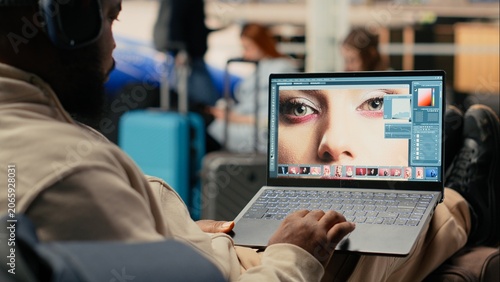 Photos Photographer reviewing images, digital nomad, at airport waiting area, using photo editing software to finalize editorial production before boarding plane, nomadic lifestyle, remote job mobility