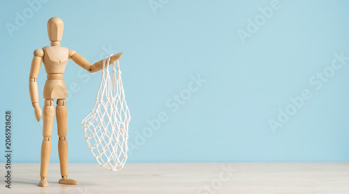 Talent acquisition resources and KPI tracking concept with a wooden mannequin holding an empty string mesh bag with copy space for HR presentation slide banner