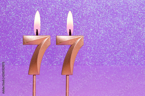 Number 77 on a pink background with blurred bright dots - Birthday or anniversary card with abstract blurred dots that glow