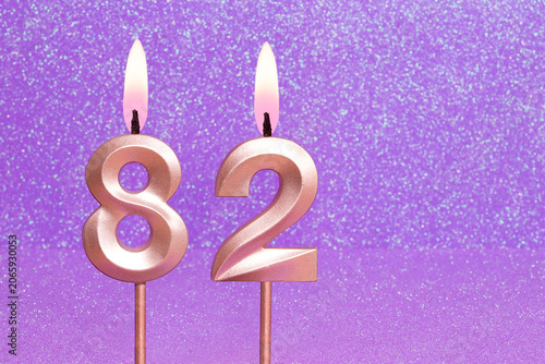 Number 82 on a pink background with blurred bright dots - Birthday or anniversary card with abstract blurred dots that glow