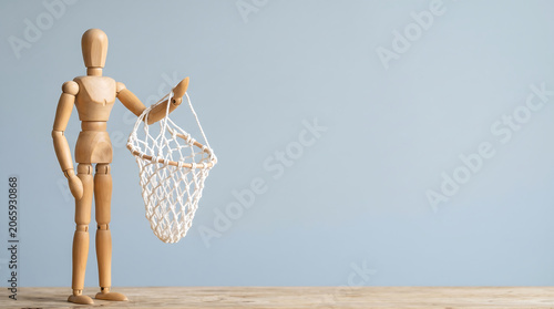 Mid-year performance reviews and KPI tracking concept with a wooden mannequin holding an empty mesh net with copy space for a business growth analysis presentation banner
