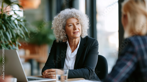 Recruiter listening during executive hiring interview, natural daylight, blurred office background