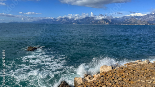 Rocky coastal seascape with waves and distant mountains in bright spring light, ideal for travel editorial, tourism promotion and social media, 5 May 2026 Subitica, Serbia