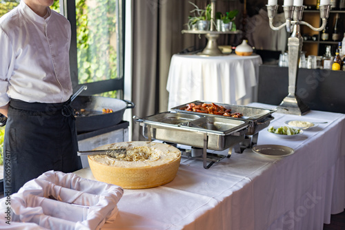 Foto Catering service sets up food station with various dishes at event venue in afte