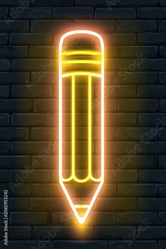 Neon pencil sign glowing on a dark wall in an urban setting at night