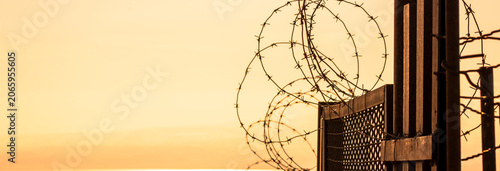 фотографія High-security prison area with barbed wire fencing and restricted access, symbolizing confinement, law enforcement, controlled environment, and strict protection of a secure facility