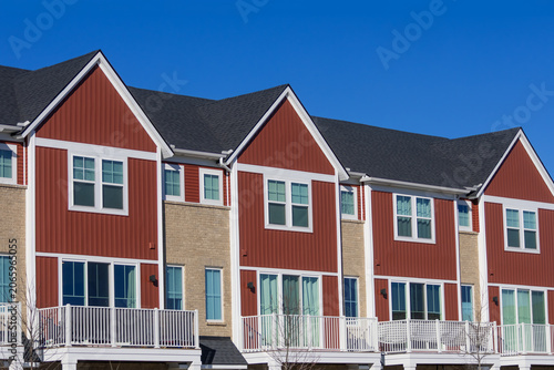 Modern townhouses with red siding and balconies