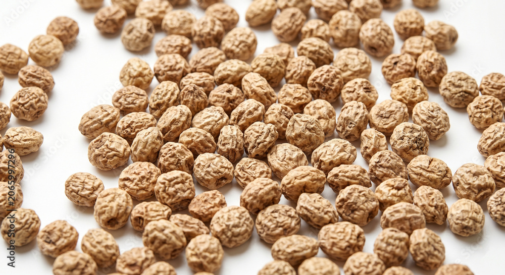 Fototapeta premium Raw Dried Tigernuts Scattered on White Background Macro