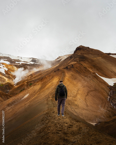 фотографія Rear View of Hiker Walking on Mountain Ridge Trail in Kerlingarfjöll Geothermal
