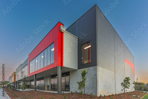 Canvastavla Contemporary industrial warehouse and office building with bold red facade, modern glazing and clean architectural lines