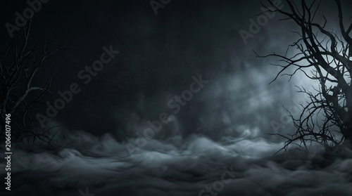 Spooky dark forest background with thick fog dry bare trees and mystical moonlight atmosphere