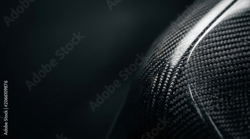 Close up of curved carbon fiber surface with woven texture
