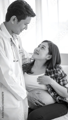A black-and-white photo of a doctor and a pregnant woman