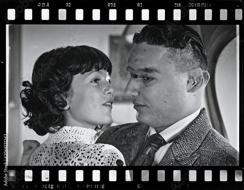 A black-and-white photo of a man and woman looking at each other