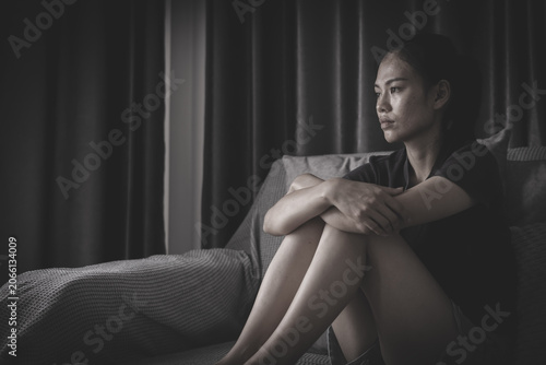 Obraz na płótnie A woman with a sorrowful expression symbolizes depression, loneliness, fear, and the emotional consequences of gender based violence