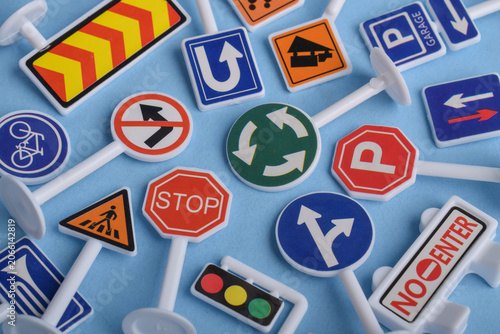 Принти на полотні Assorted miniature traffic signs and road symbols arranged on blue background, representing transportation, road safety, traffic regulations, navigation, and urban infrastructure concepts