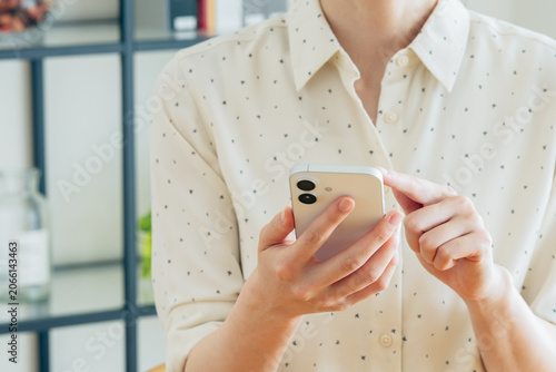Fotografía 家でスマートフォンを使う若い女性の手元