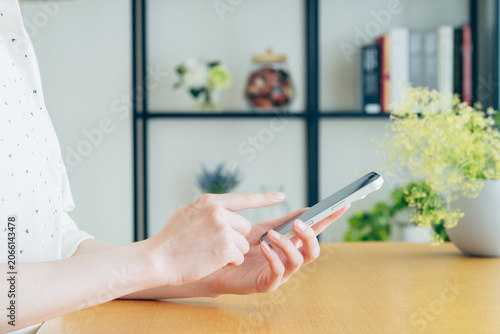 Foto 家でスマートフォンを使う若い女性の手元