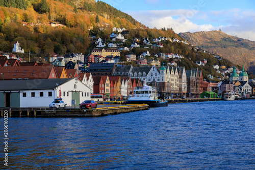 Panorama of Bergen Port with colorful wooden hanseatic buildings of Bryggen, Ferry, warehouse and mountain Ulriken in autumn in Norway