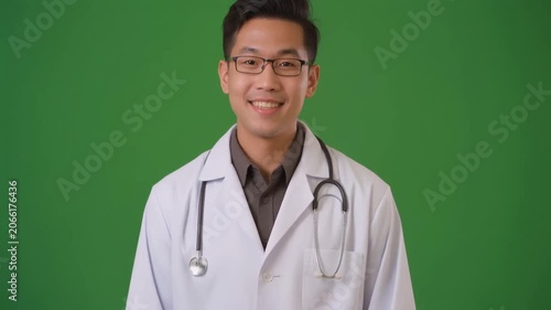 Friendly male doctor gesturing on green screen