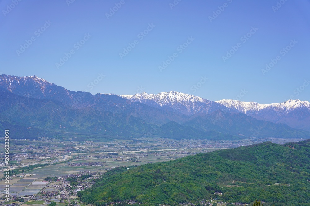 Fototapeta premium 信州 安曇野 長峰山から望む残雪の北アルプスと新緑の安曇野 蓮華岳 針ノ木岳