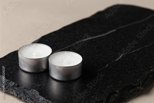 Fotografia A pair of tealight candles on black stone