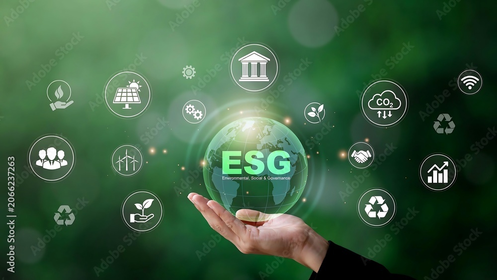 Fototapeta premium A person holds a glowing green globe with ESG icons surrounding it.
