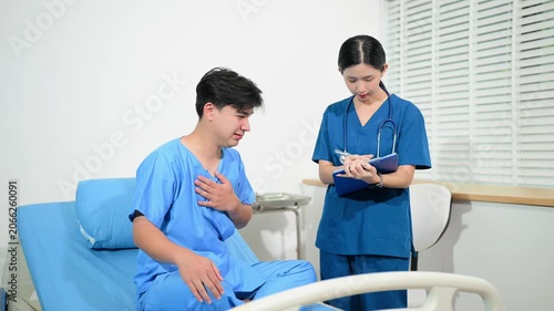 Professional female doctor discussing medical chart with an Asian patient in a hospital bed.