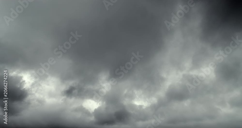 Dense, gray storm clouds move across the sky, indicating an approaching heavy rainstorm.