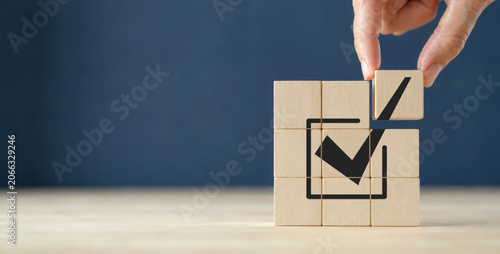 Corporate regulatory and compliance. Goals achievement and business success. Task completion. Ethical corporate. Do the right thing. Quality and ISO symbol. Placing wooden cube with checkmark icon.