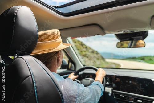 Woman driving mountain road through Catalan Pyrenees with panoramic sunroof