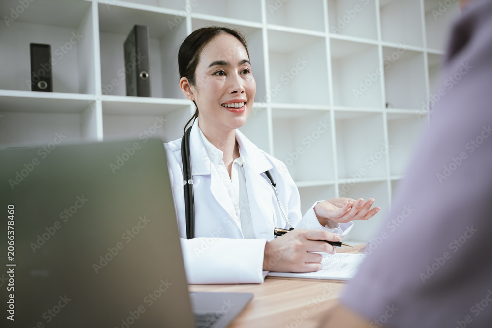 Fototapeta premium Female doctor consulting with a patient using a laptop in a modern clinic, discussing health information, treatment options, medical records, and personalized healthcare services.