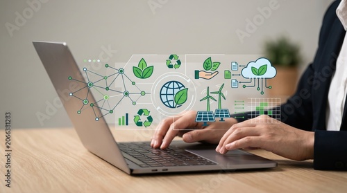 Businessman typing on laptop with holographic green technology icons, renewable energy, sustainability, ecology and digital network concept for corporate environmental