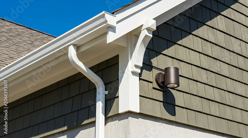 White gutter system and exterior wall siding with outdoor light downspout house