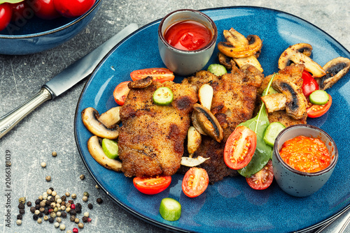Crispy breaded pork chops with a vegetable garnish