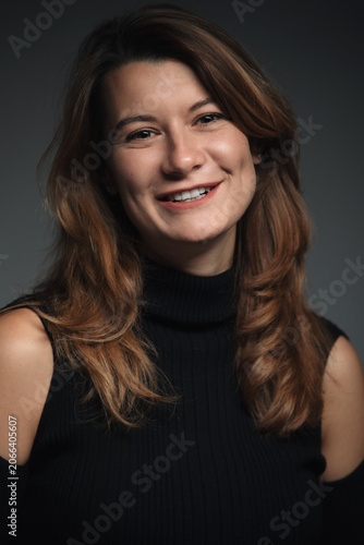 Portrait of a beautiful woman smiling. Dark background, close-up.