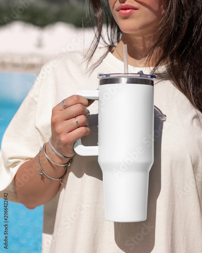 Blank white 40oz tumbler mockup, young woman at poolside, hand close up. Lifestyle scene
