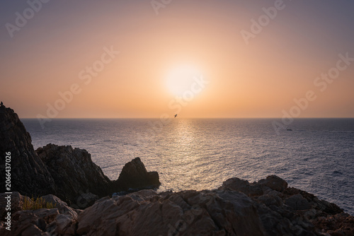 Sunset over the coast, rock formations, big ball sunshine