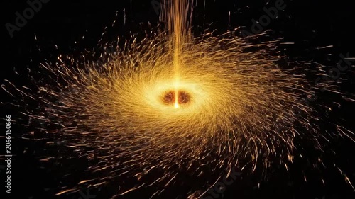 Golden sparks spiral outward in a vibrant circular motion against a dark background
