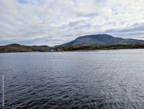 Aquaculture salmon and mussel farm rings floating in the waters of Killary Harbour fjord in Connemara, Ireland, surrounded by rugged mountains.