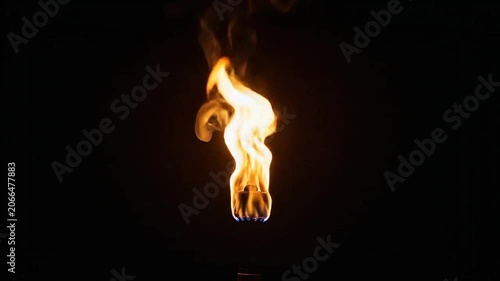 A bright orange flame burning intensely against a solid black background