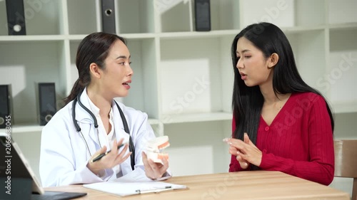 Professional dentist consulting with a patient in a modern dental clinic, explaining teeth restoration, prosthetic options, oral health care, treatment plans, and dental hygiene during a routine check